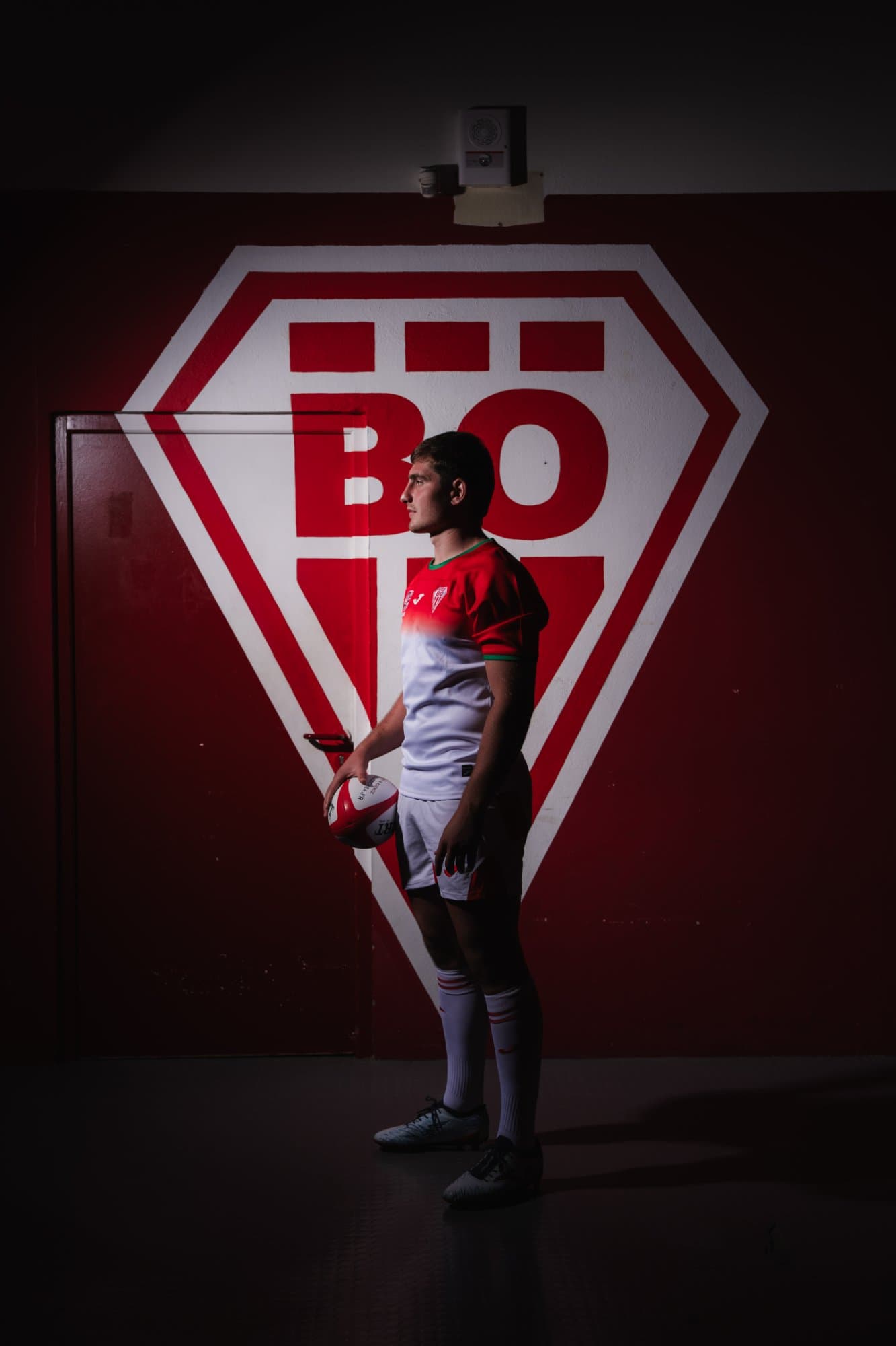 Biarritz Olympique player standing in front of the red and white BO crest
